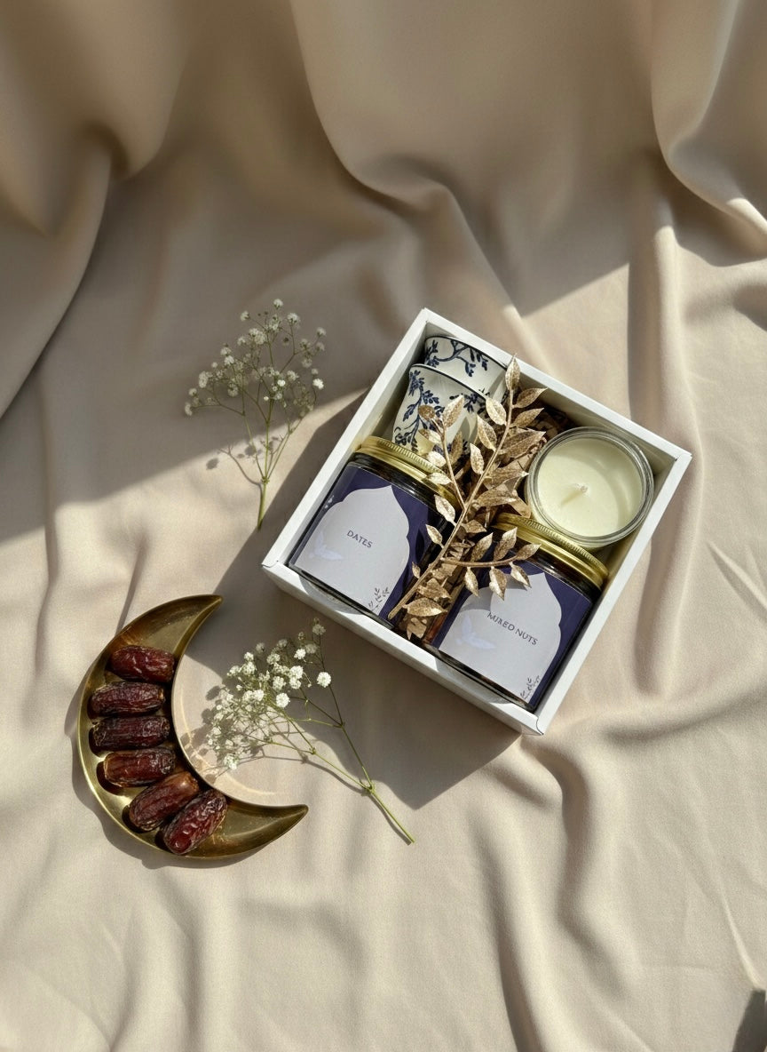 Blue Noor Box gift set featuring a jar of dates, mixed nuts, kahwa cups, and a small candle.
