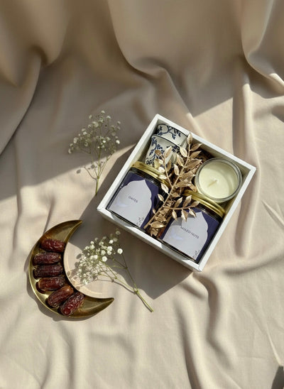 Blue Noor Box gift set featuring a jar of dates, mixed nuts, kahwa cups, and a small candle.