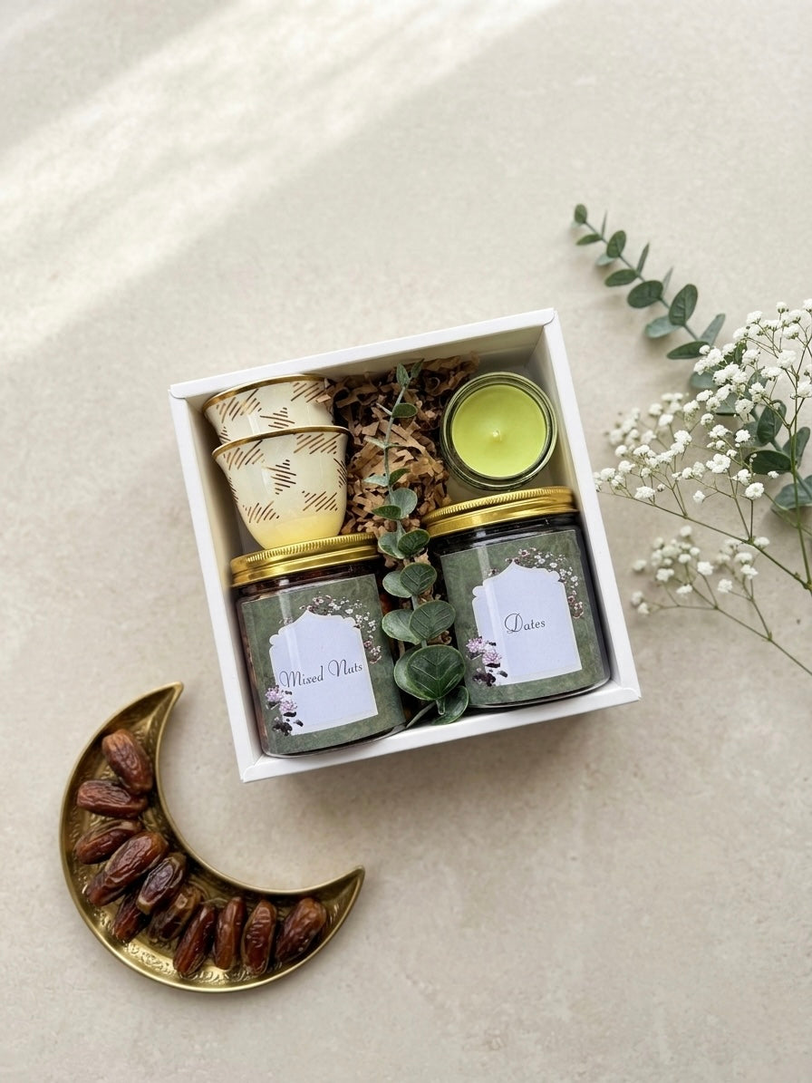 Eid joy box gifts featuring a jar of dates, jar of mixed nuts, kahwa cups, and a mini candle in an elegant arrangement.