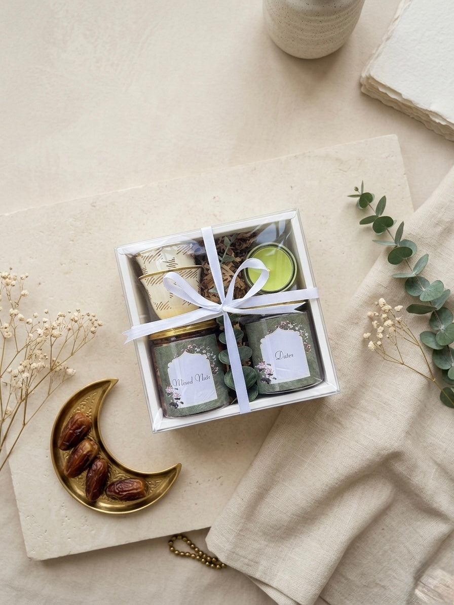 Eid joy box gifts featuring jar of dates, mixed nuts, kahwa cups, and mini candle arranged in a gift box.