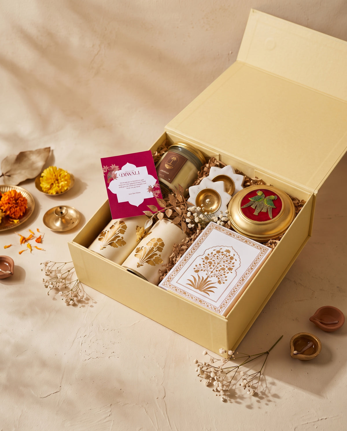 Golden Haveli Box filled with luxury Diwali items including candles, brass tin, and decorative elements.