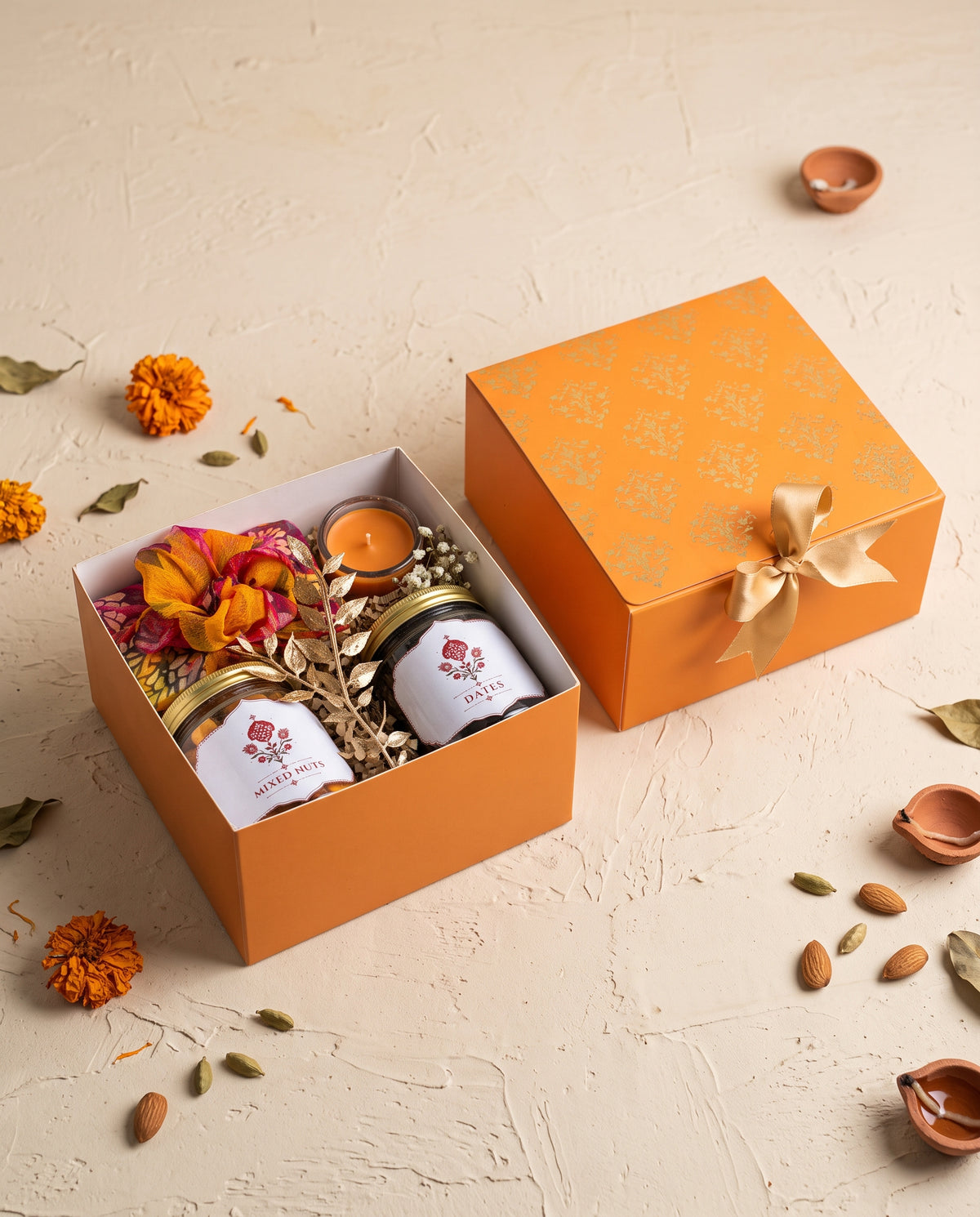 Saffron Glow Diwali Box with mixed nuts, dates, and a mini candle, perfect for corporate gifting.