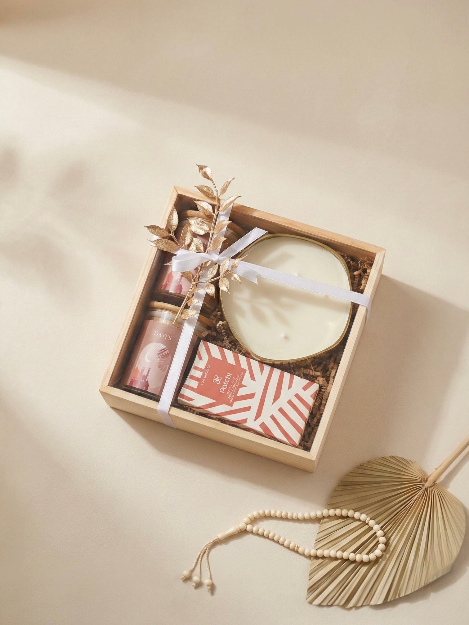 Saffron spice gift box featuring a scented candle, mixed nuts, and chocolate in a wooden box.