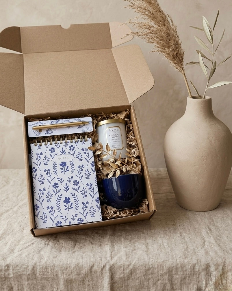 The Blue Note Ritual Box featuring a blue floral gift set with a notebook, candle, and mug.