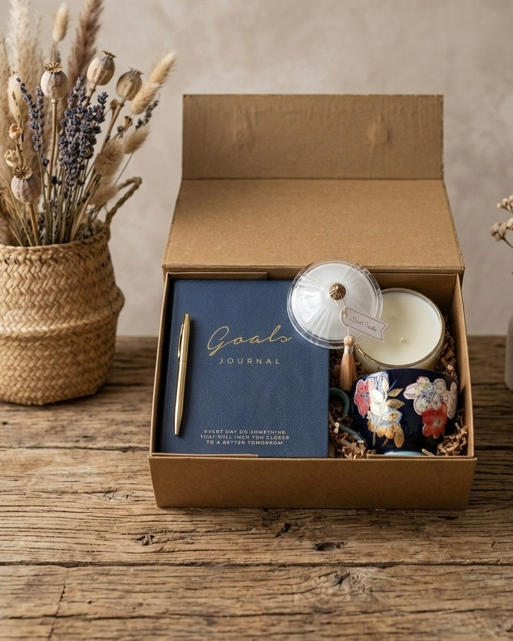 The Goal Setter Gift Box featuring a goals journal, gold pen, luxury candle, and floral navy mug.
