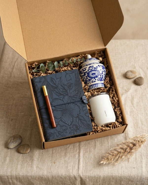 Luxury navy gift box with navy floral embossed journal, wooden pen, and blue & white scented candle.