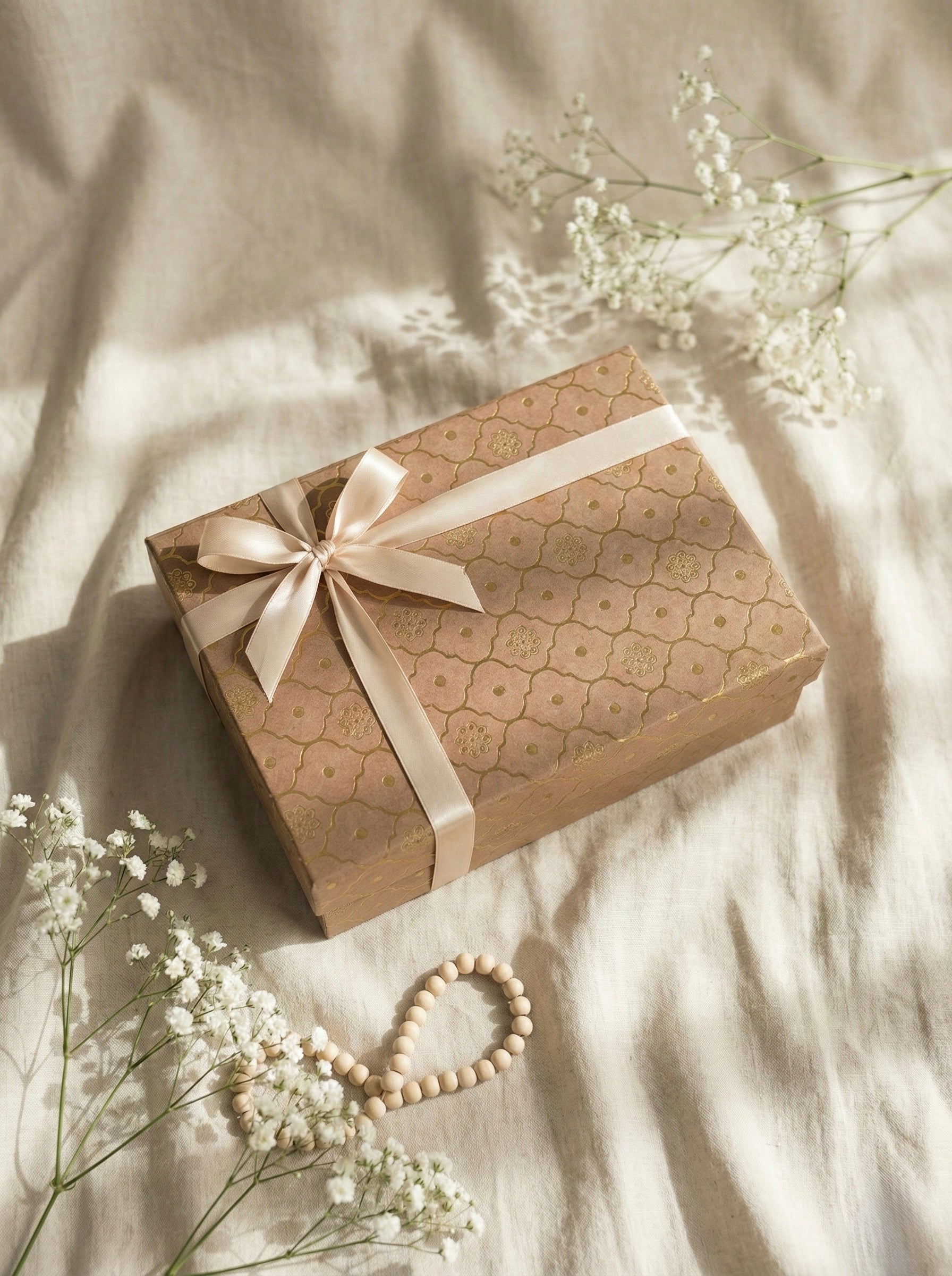 The Sukoon Box, a perfect Eid gift hamper UAE, elegantly wrapped with ribbon, surrounded by flowers.