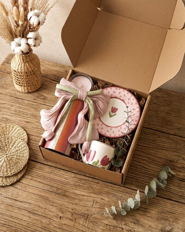 Tulip gift set featuring a vintage rose tin, pink tulip cup, saucer, scented candle, and hair clip in eco-friendly box.
